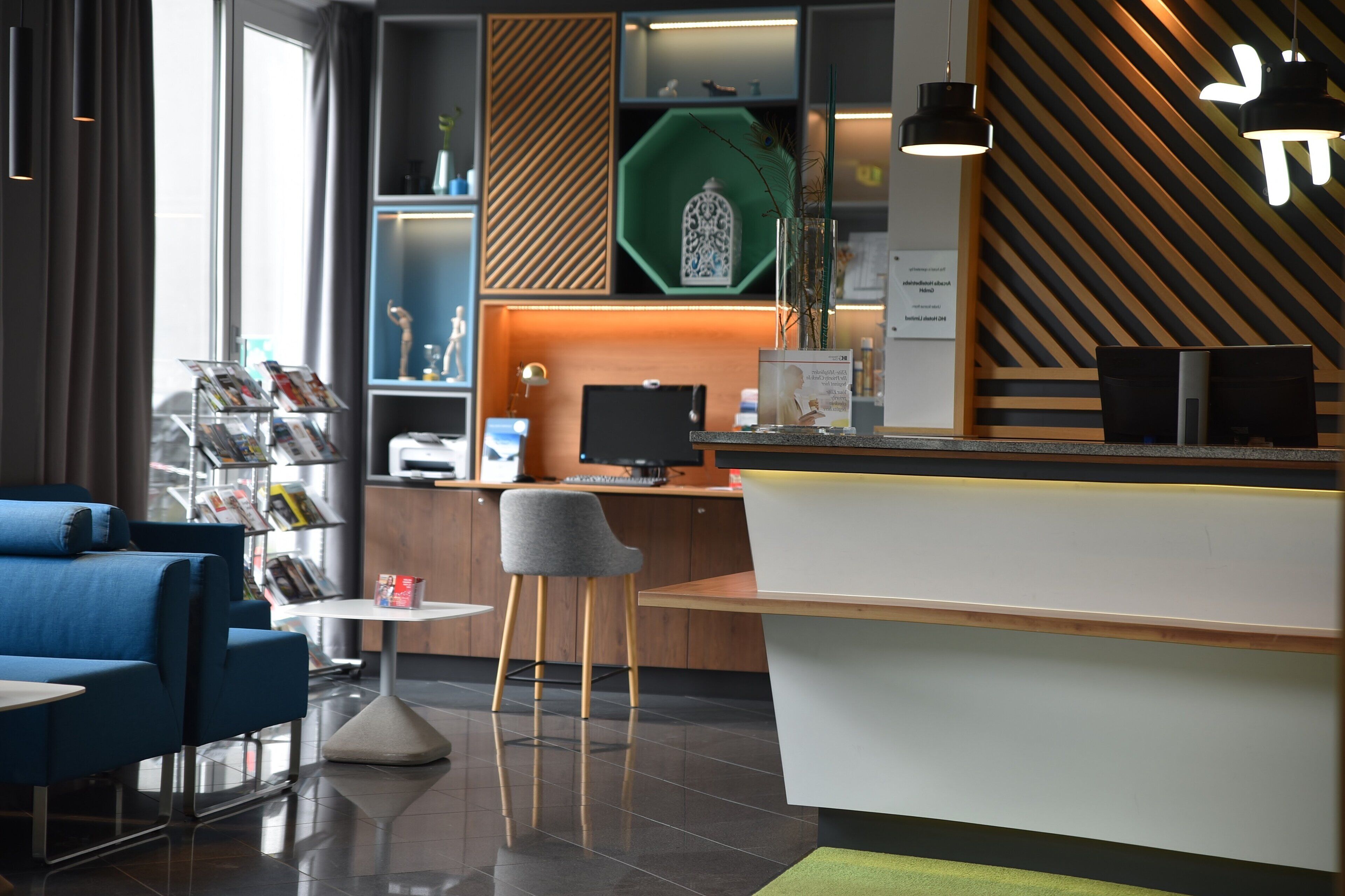 A modern reception area with a desk, computer, and seating.