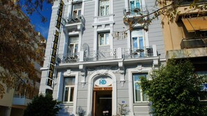 A multi-story hotel with a classic architectural style, featuring balconies and a prominent entrance with a sign. - Hotel Diethnes (Athens)
