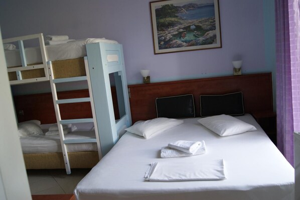 A hotel room with a bunk bed, a single bed, a painting on the wall, and a window with curtains. - Hotel Diethnes (Athens)