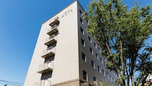 A multi-story hotel with balconies on the lower floors and a sign indicating it is the "HOTEL METS". - JR East Hotel Mets Musashisakai (Musashino)