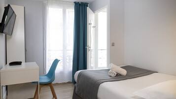 Une chambre à coucher avec un lit, un bureau et une chaise.