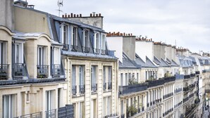 A row of historic European-style buildings with uniform facades, large windows, and balconies. - Hôtel Paris Legendre (Paris)