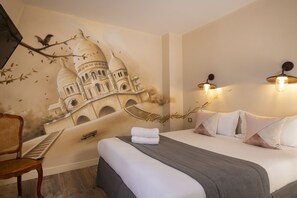 A hotel room with a mural of a historical building, a bed with white linens, a grey throw, and two wall-mounted lights.