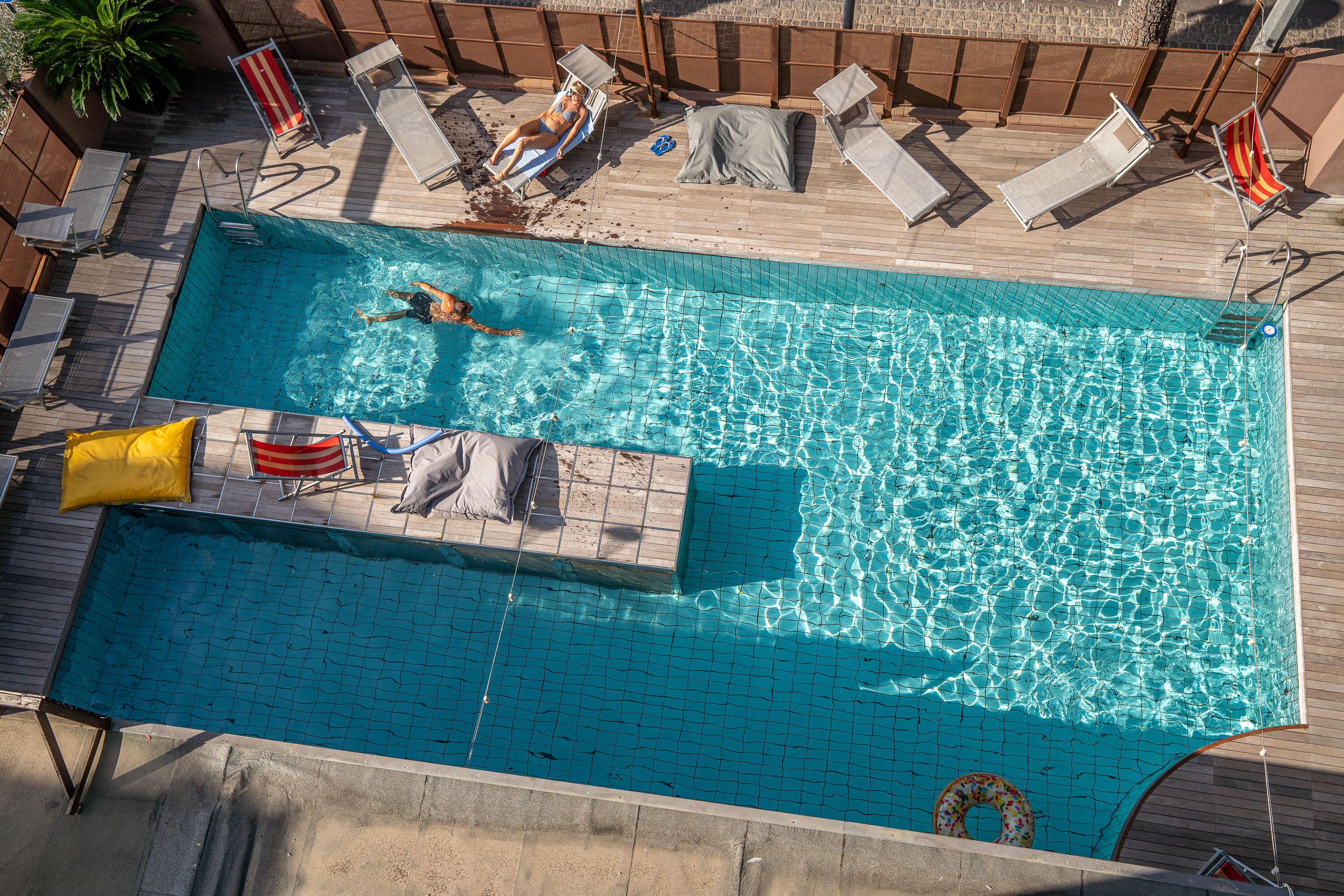 Una piscina al aire libre de temporada, sillones reclinables de piscina