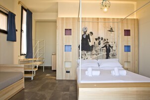 Una camera d'albergo moderna con un letto in legno, una scala e un grande murale sulla parete.
