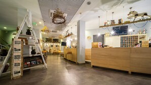 Un moderno vestíbulo de hotel con recepción, zona de estar y una llamativa exhibición de escaleras decorativas.