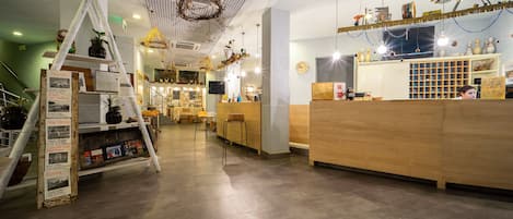 A modern hotel lobby with a reception desk, seating area, and a decorative ladder display.