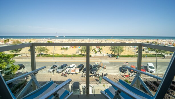 Vista desde un balcón alto sobre un estacionamiento y una playa.