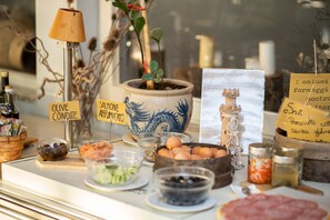 A display of food items including olives, salmon, and eggs, with labels and a decorative lamp.