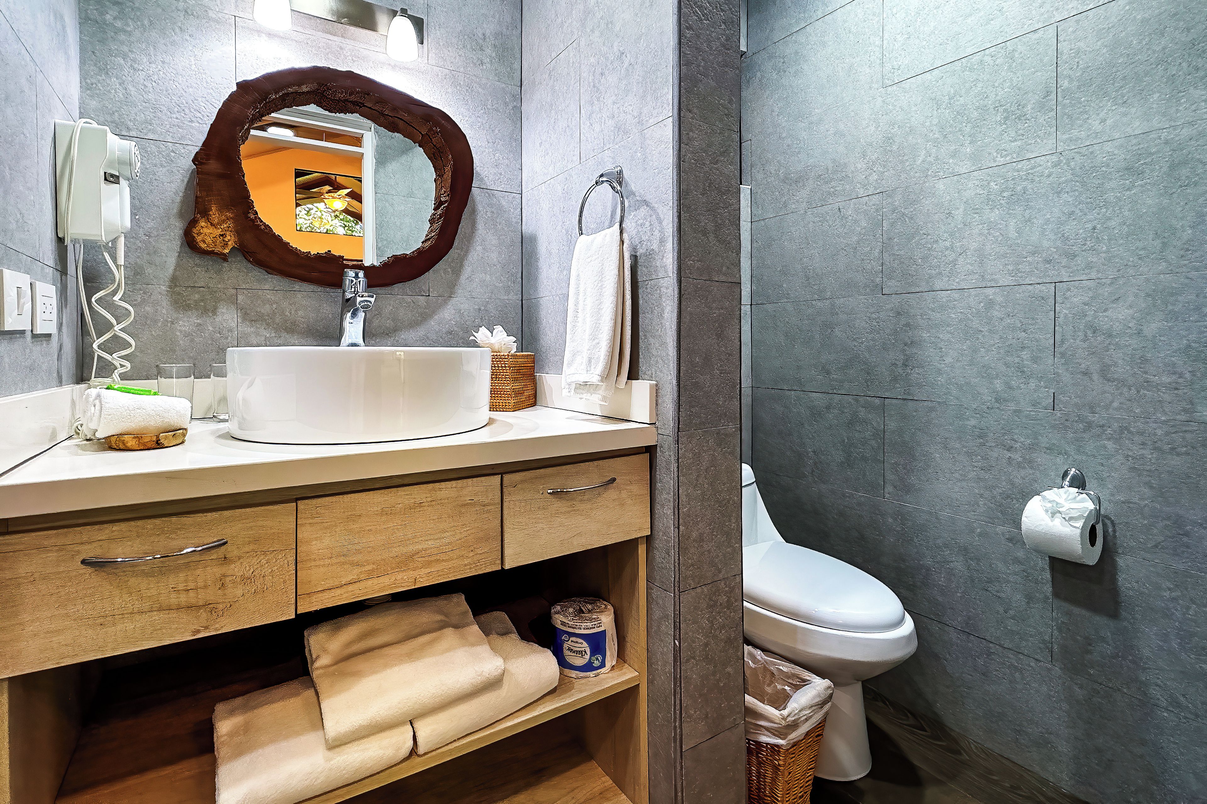 A bathroom with a white sink, a mirror, a towel rack, and a toilet.