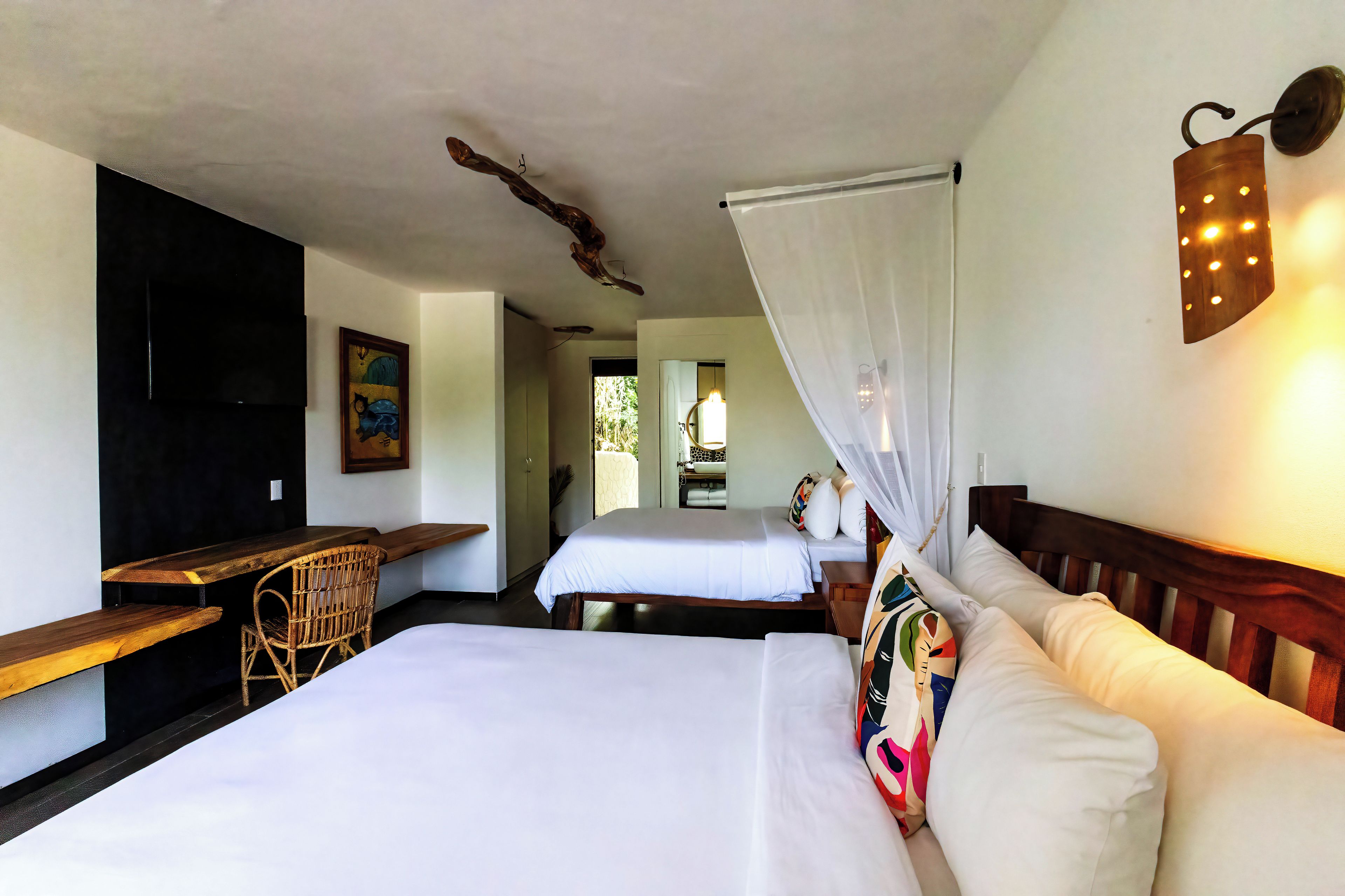 Habitació d'hotel amb dos llits, un escriptori i una cadira.