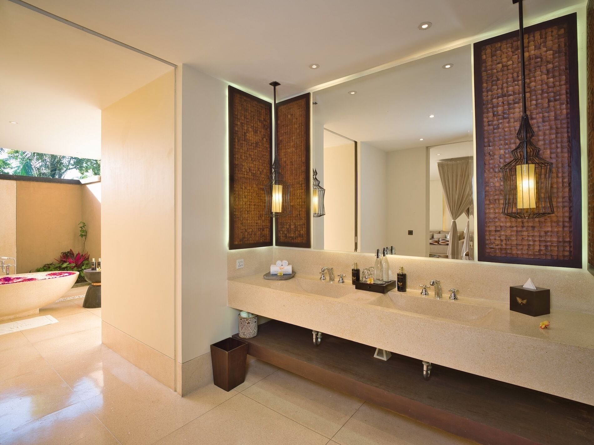A modern bathroom with a large mirror, a bathtub, and a vanity with multiple sinks.