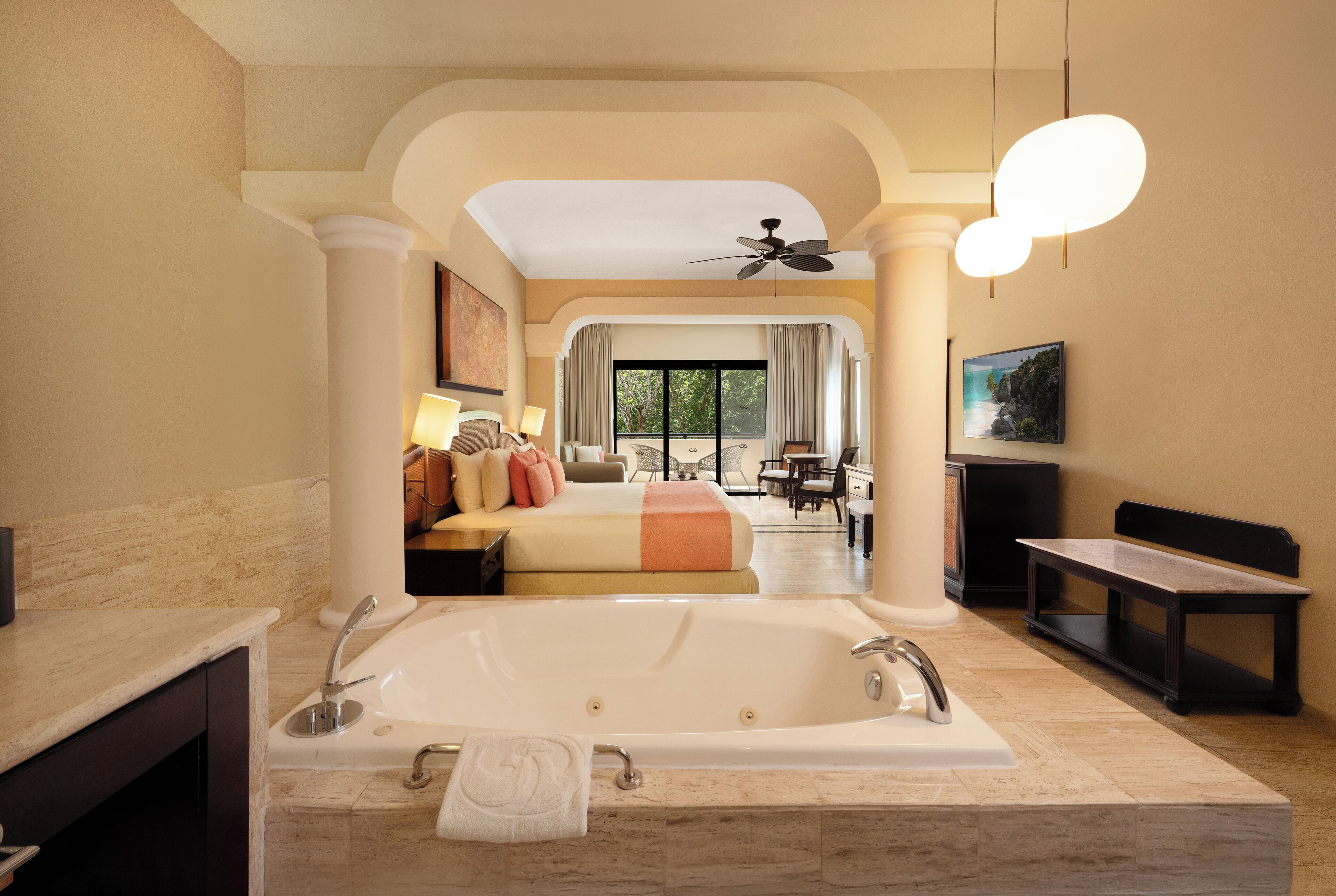 Un baño amplio con una bañera grande, un sofá al fondo y vistas al exterior.