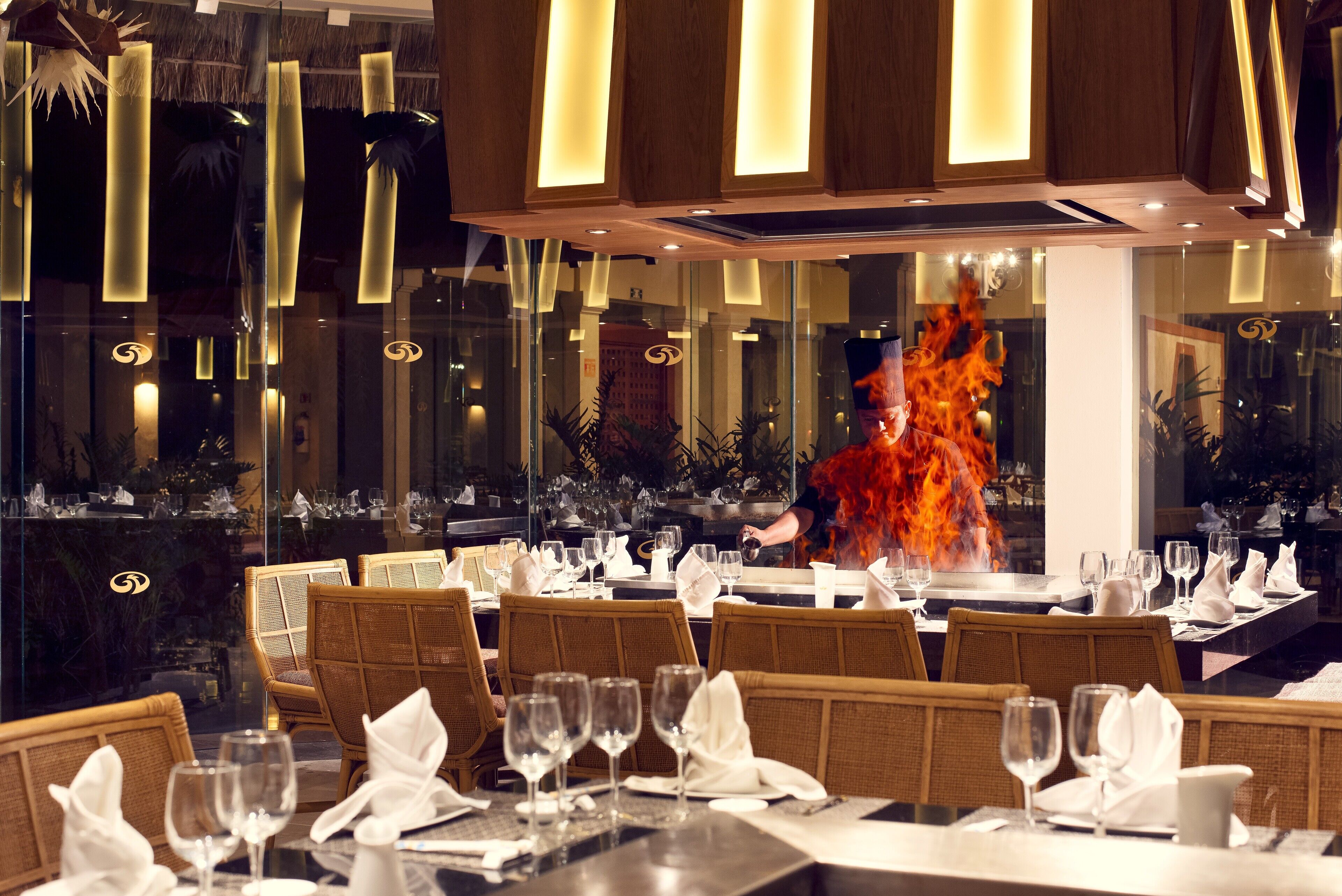 En restaurang med dukade bord, en eldstad i bakgrunden och en modern inredning.