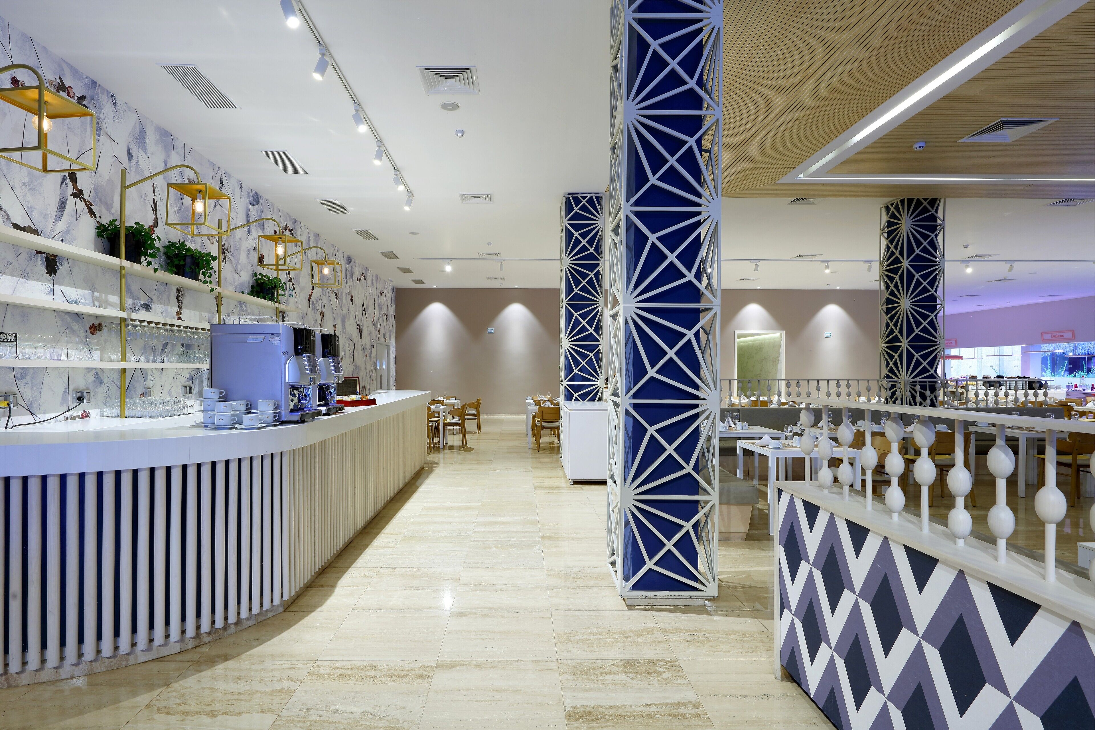 Um hall de hotel moderno com balcão de recepção, área de estar e colunas decorativas.