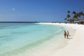 On the beach, white sand, sun loungers, beach towels