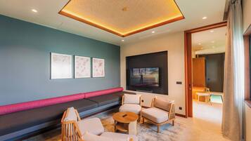 Una sala moderna con un sofá modular, un televisor de pantalla plana y una mesa de centro.