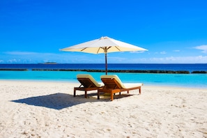 Privatstrand, weißer Sandstrand, Liegestühle, Sonnenschirme