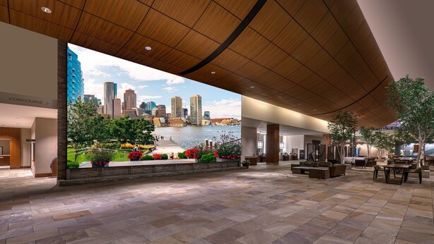 Un hall d’entrée spacieux, orné d’une grande fresque représentant une vue panoramique de la ville et offrant un aperçu du front de mer.