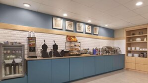 A self-service breakfast station with a coffee machine, waffle maker, and a variety of food items. - Country Inn & Suites by Radisson, Beavercreek-Dayton (Dayton)