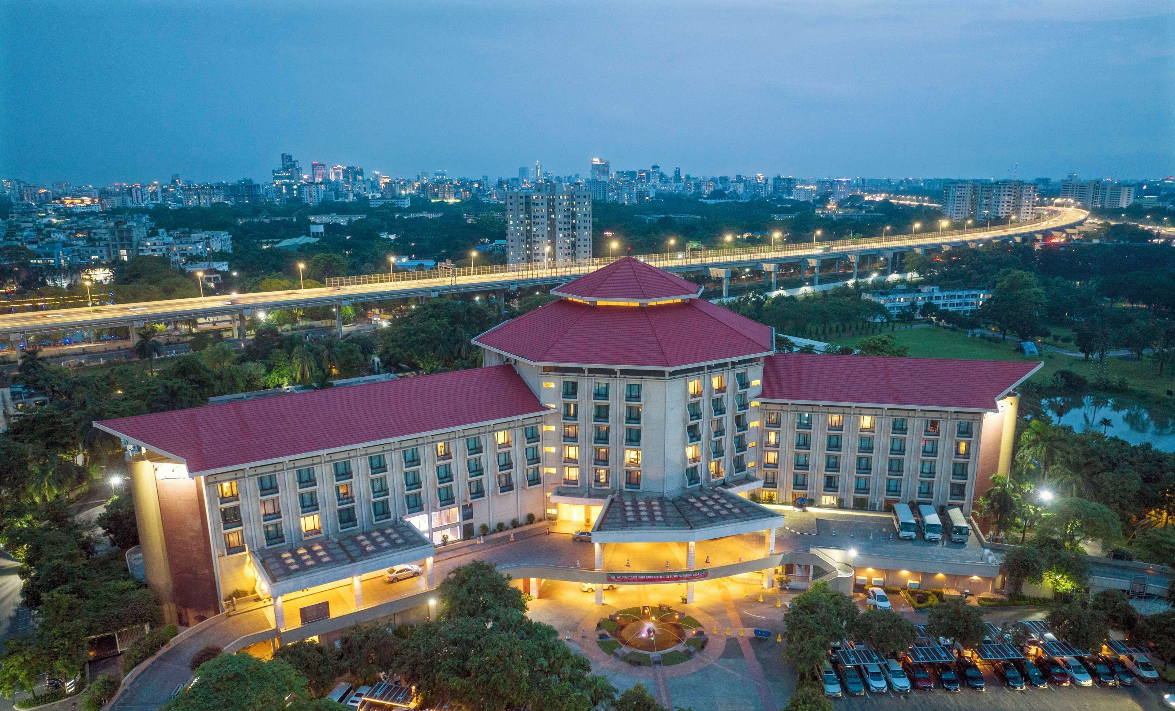 A large, multi-story building with a distinctive red roof and a central circular structure.