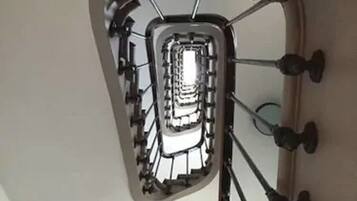 A spiral staircase with a central glass enclosure.