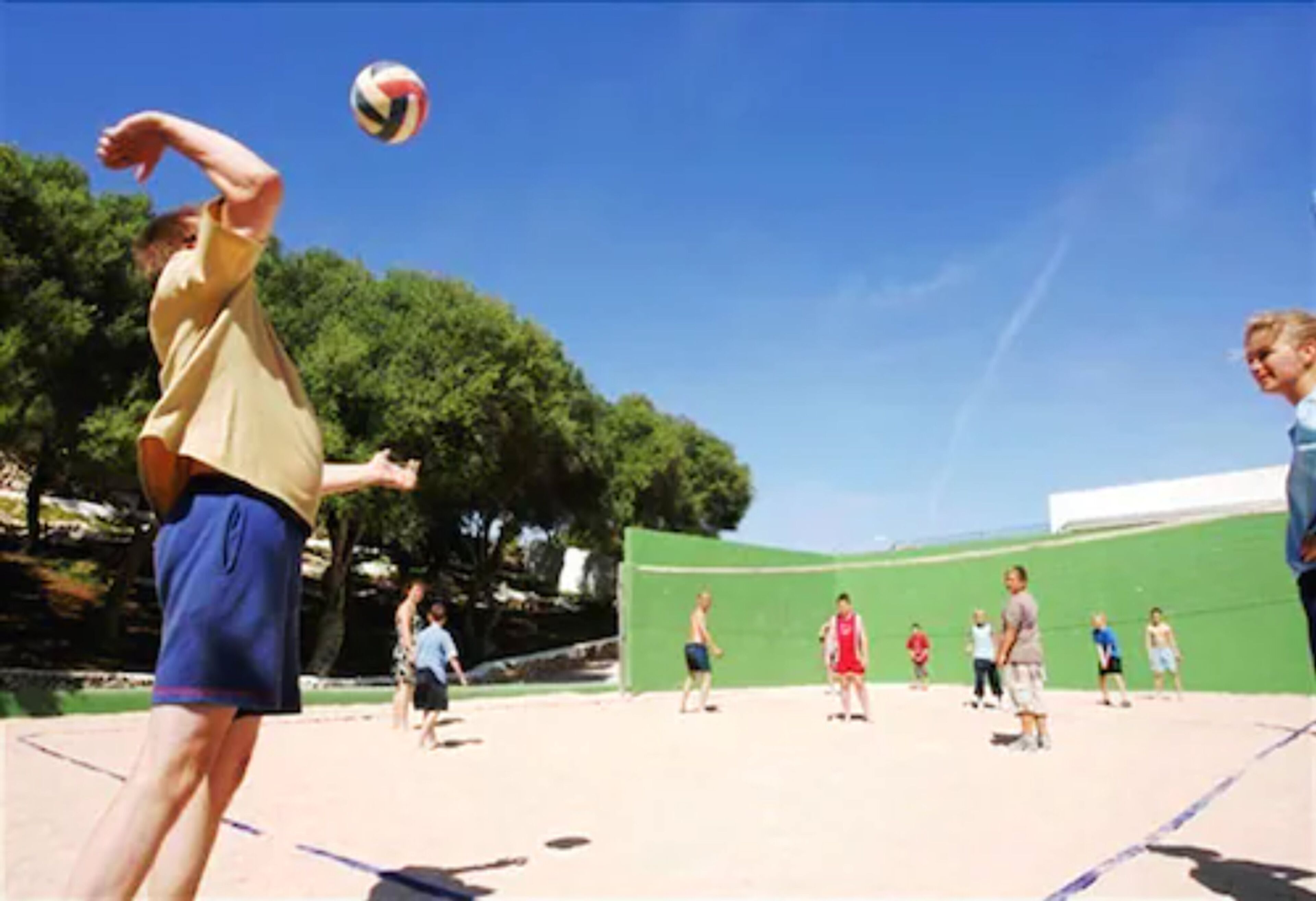 Una cancha de voleibol con jugadores y espectadores.