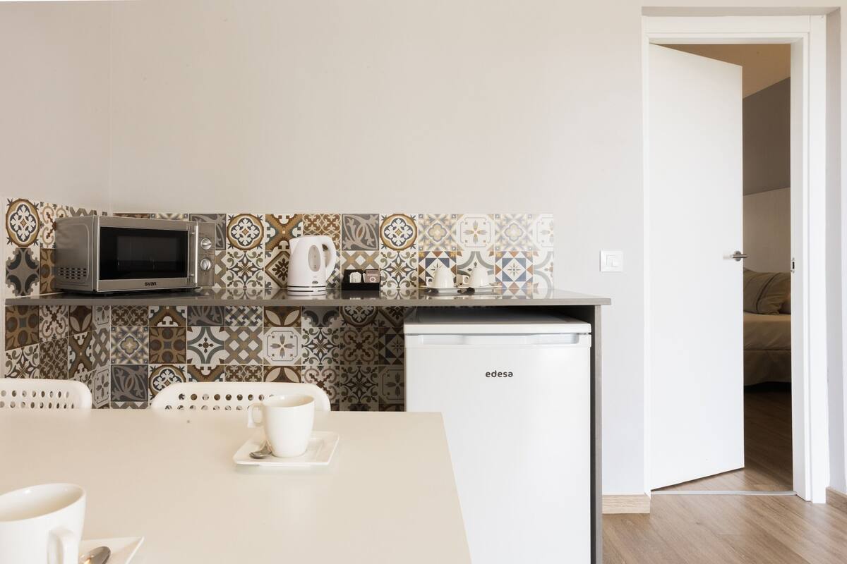 A modern kitchen with a microwave, coffee maker, and a dishwasher.