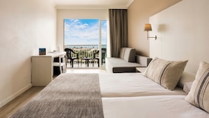 Une chambre d’hôtel équipée d’un lit, d’un bureau, d’une chaise, d’un canapé et d’un balcon avec vue.