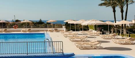 Kolam renang outdoor, dengan payung kolam renang dan kursi berjemur