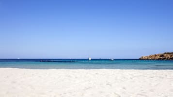 Di pantai, kursi berjemur, payung pantai, dan handuk pantai