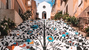 A staircase with colorful geometric patterns leading to a building with a bell tower. - Grand Hotel in Porto Cervo (Arzachena)