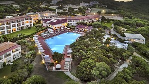 A resort with a central pool, multiple buildings, and lush greenery. - Grand Hotel in Porto Cervo (Arzachena)