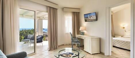 Una habitación de hotel con balcón, escritorio, cama y sofá.