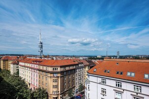 Paisagem urbana com edifícios históricos, uma torre imponente e céu claro.