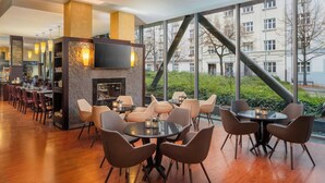 Un restaurante moderno con chimenea, mesas redondas y asientos cómodos.