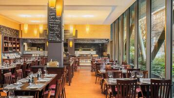 Un restaurante con varias mesas, sillas y un menú en una pizarra.