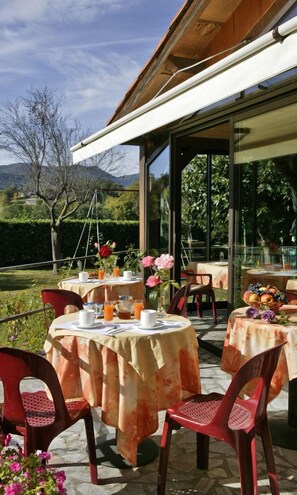 Enjoy al fresco dining amidst lush gardens and distant mountains.