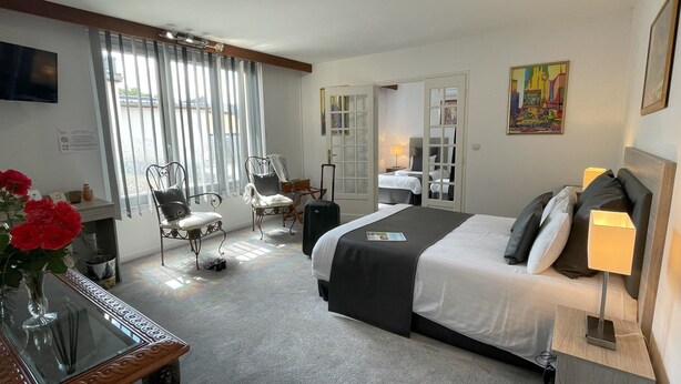 A hotel room with a bed, a desk, a chair, a TV, and a window with curtains. - The Originals Boutique, Hôtel Clos St Marie (Nevers)