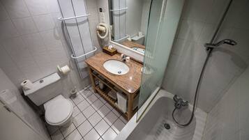 Une salle de bain équipée de toilettes, d’un lavabo, d’un miroir et d’une douche.