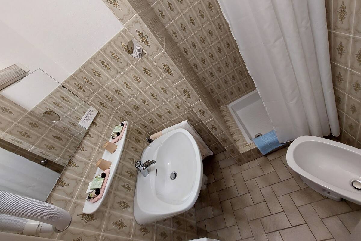 A bathroom with a bidet, a toilet, and a sink.