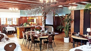 Un restaurant au décor intérieur en bois, avec de nombreuses tables et chaises.