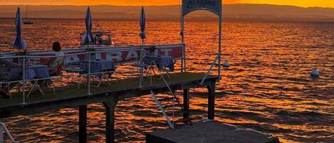 Un muelle con un cartel que dice 'Les Cygnes' y un barco amarrado cerca.