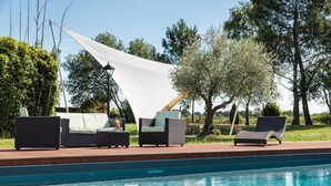 A poolside area with lounge chairs and a canopy. - l'Abreuvoir (Heric)