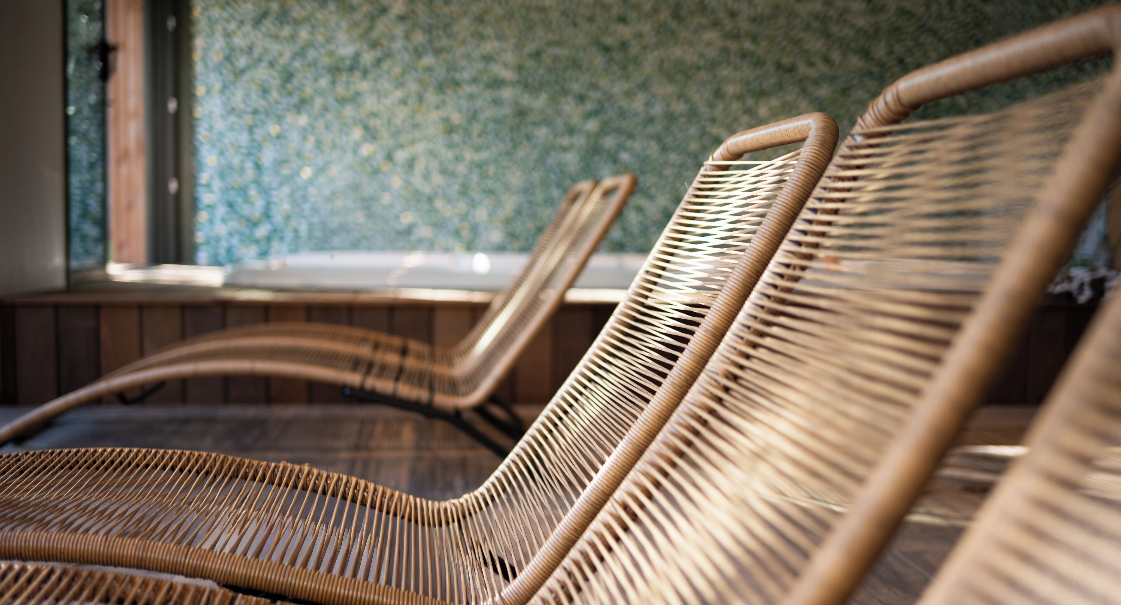 Wicker lounge chairs with a woven backrest, arranged in a row.