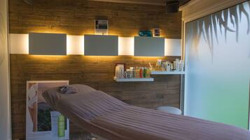 Experience relaxation in this serene spa room featuring a massage table and amenities for a rejuvenating treatment.