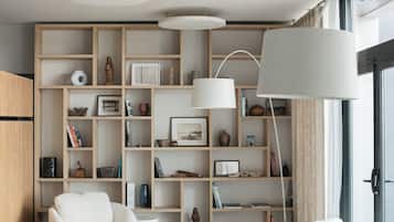 Un salon moderne avec une grande bibliothèque, un canapé blanc et un grand lampadaire.
