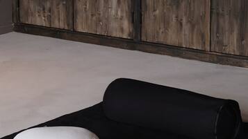 Ein Zimmer mit einer schwarzen Matte, einem weißen Kissen und einer Wandpaneele aus Holz.