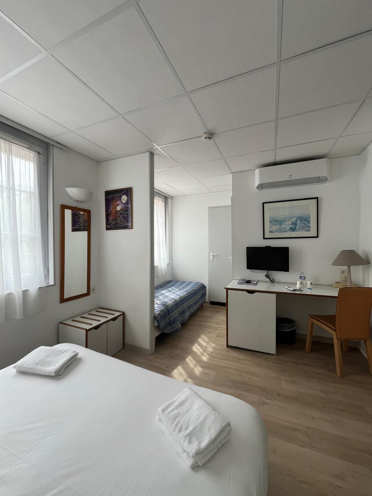 Une chambre d’hôtel équipée d’un lit, d’un bureau, d’une chaise et d’un téléviseur.