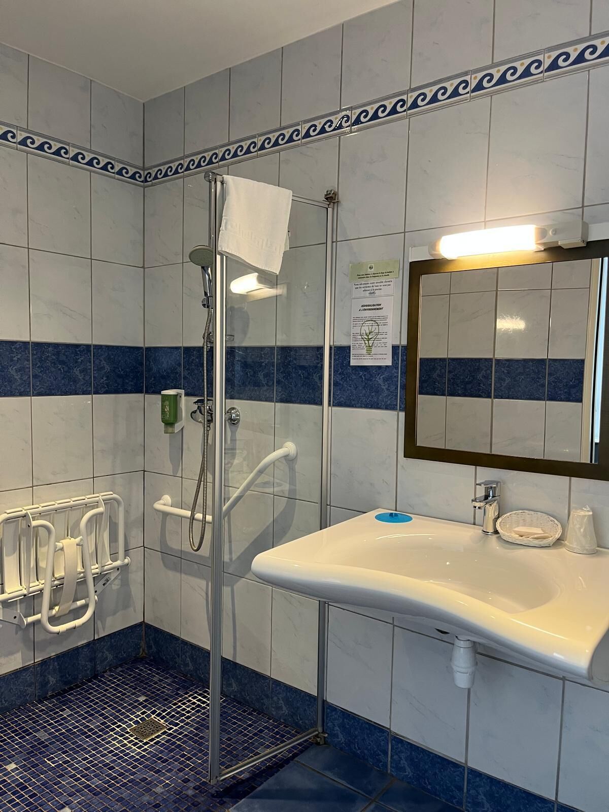 A bathroom with a shower, a sink, and a mirror.